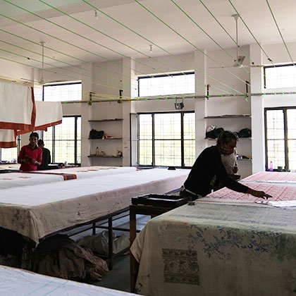 Block printing workshop and men at work printing fabric.