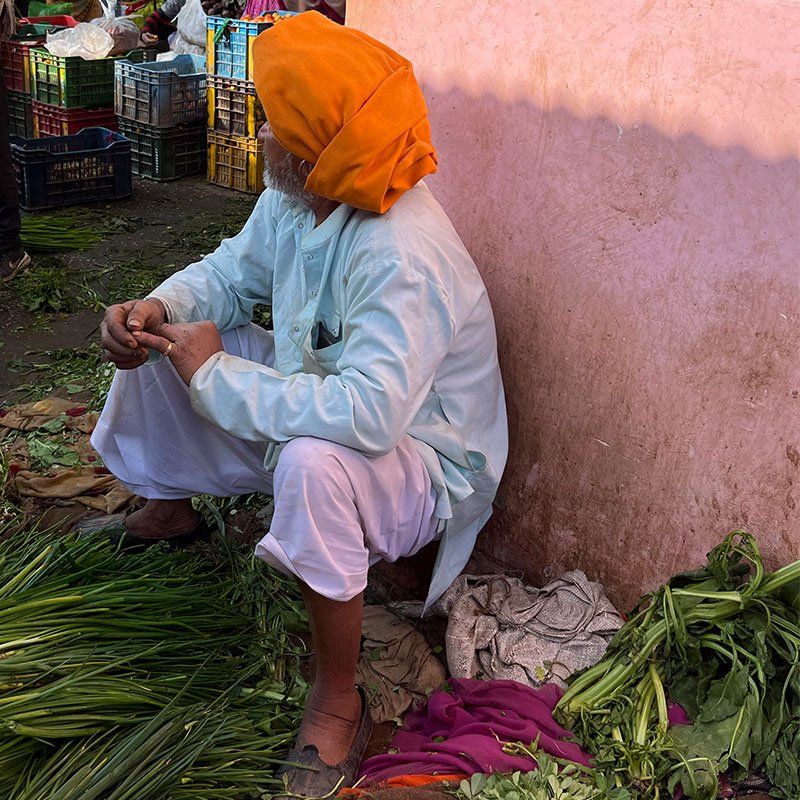 Man in bright orange turban at the Phool Mandi flower market in Jaipur.