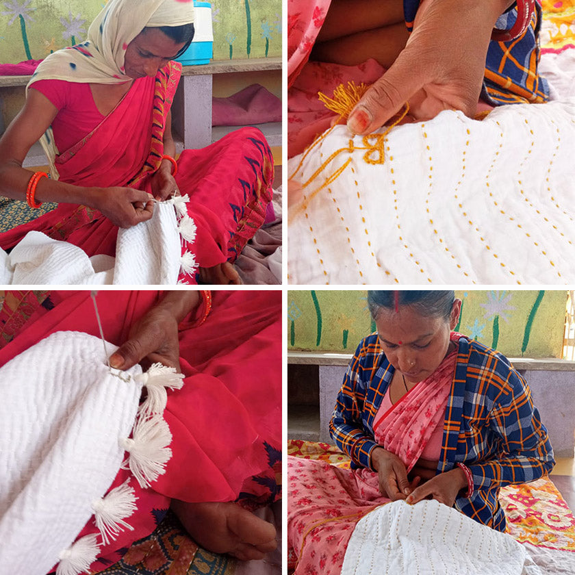 Two women stitching and embroidering quilts.