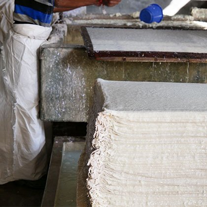 Pile of sheets of handmade paper being left to dry.