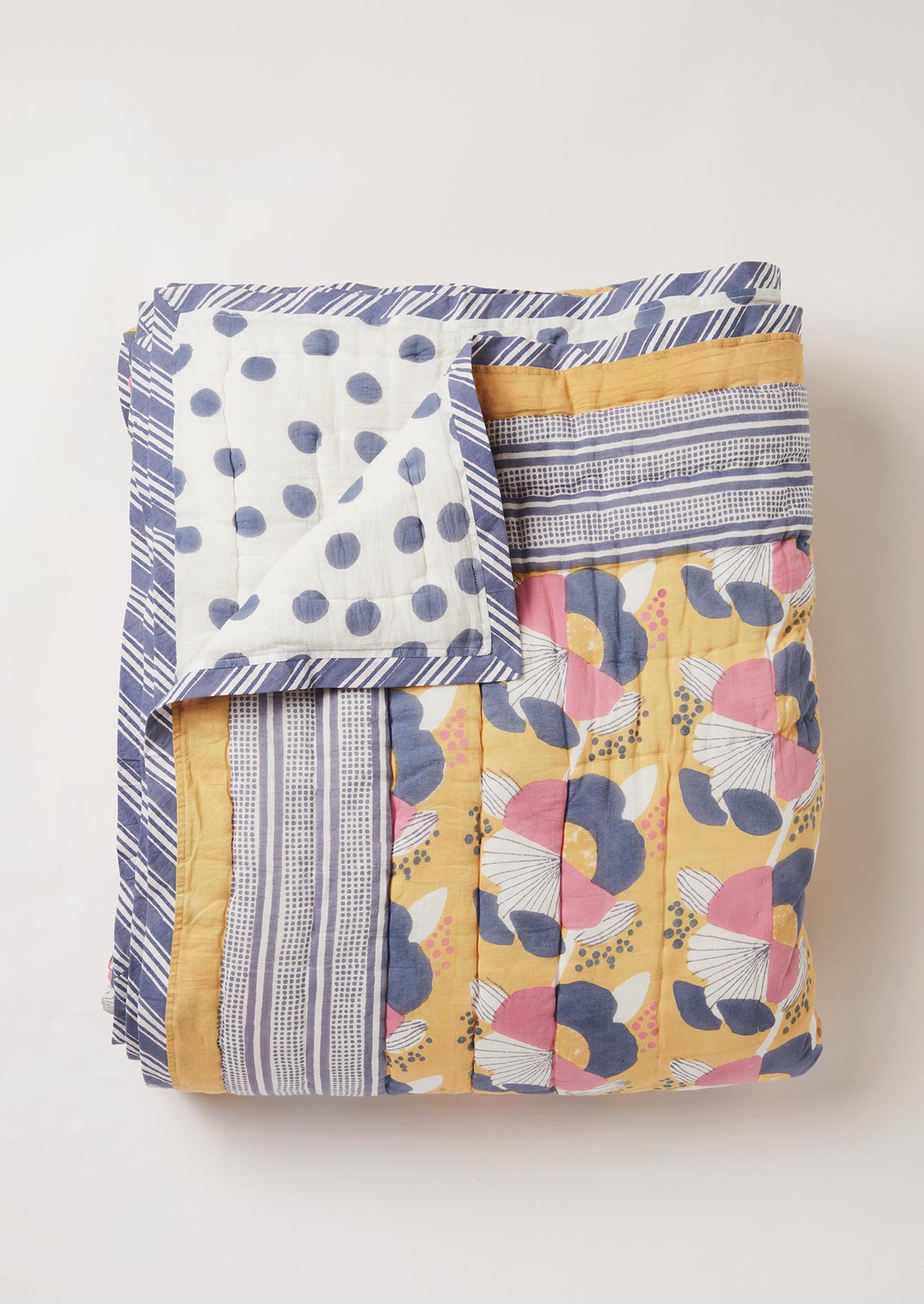 Close-up of Indian block printed floral quilt showing the polka dot print on the reverse side.