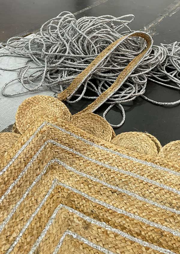 Detail of scalloped edge and silver strands on jute mat