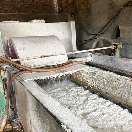 Machine processing cotton waste to make paper.