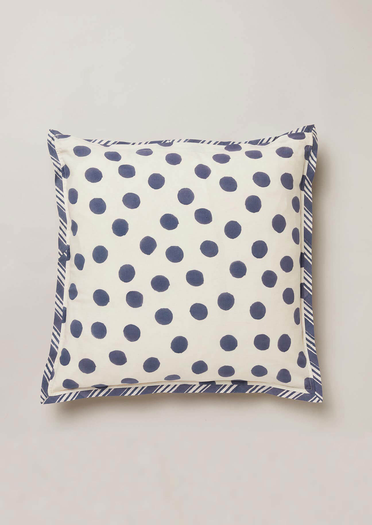 Reverside of blcok printed cushion featuring a navy polka dot design onto a white ground.