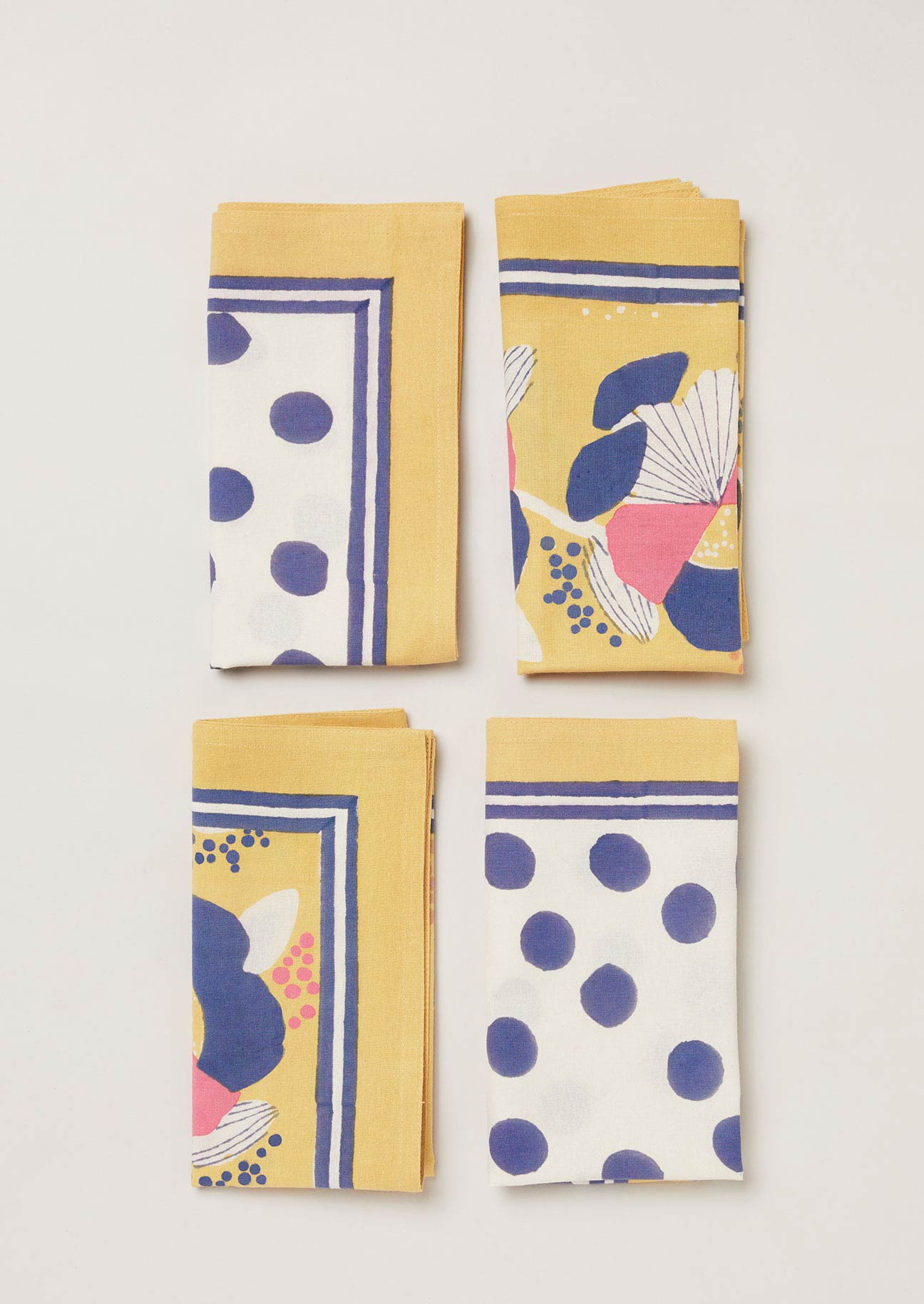 Set of 4 block printed napkins in two contrasting prints, a navy dot and  yellow and navy floral design.