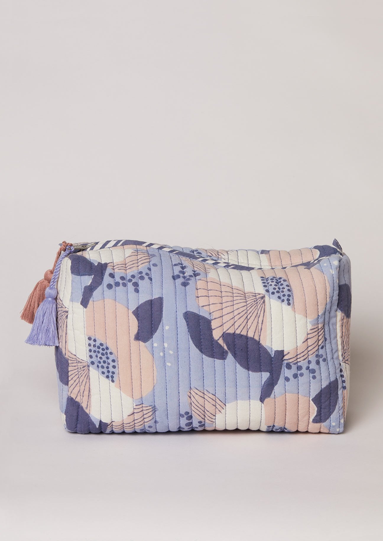 Blue wash bag with pink and white block-printed flowers and tassel detail.