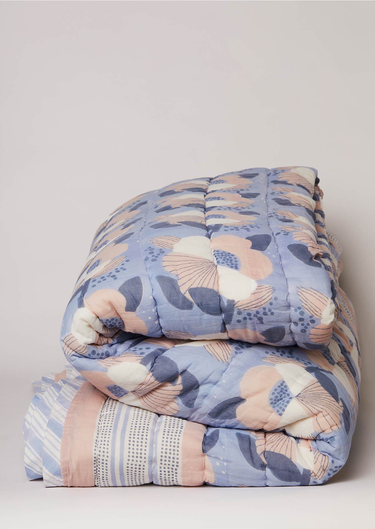 Folded block printed cotton quilt in blue and pink floral print