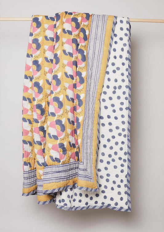 Yellow, blue and pink floral block printed quilt with stripe edge design and navy polka dot reverse.