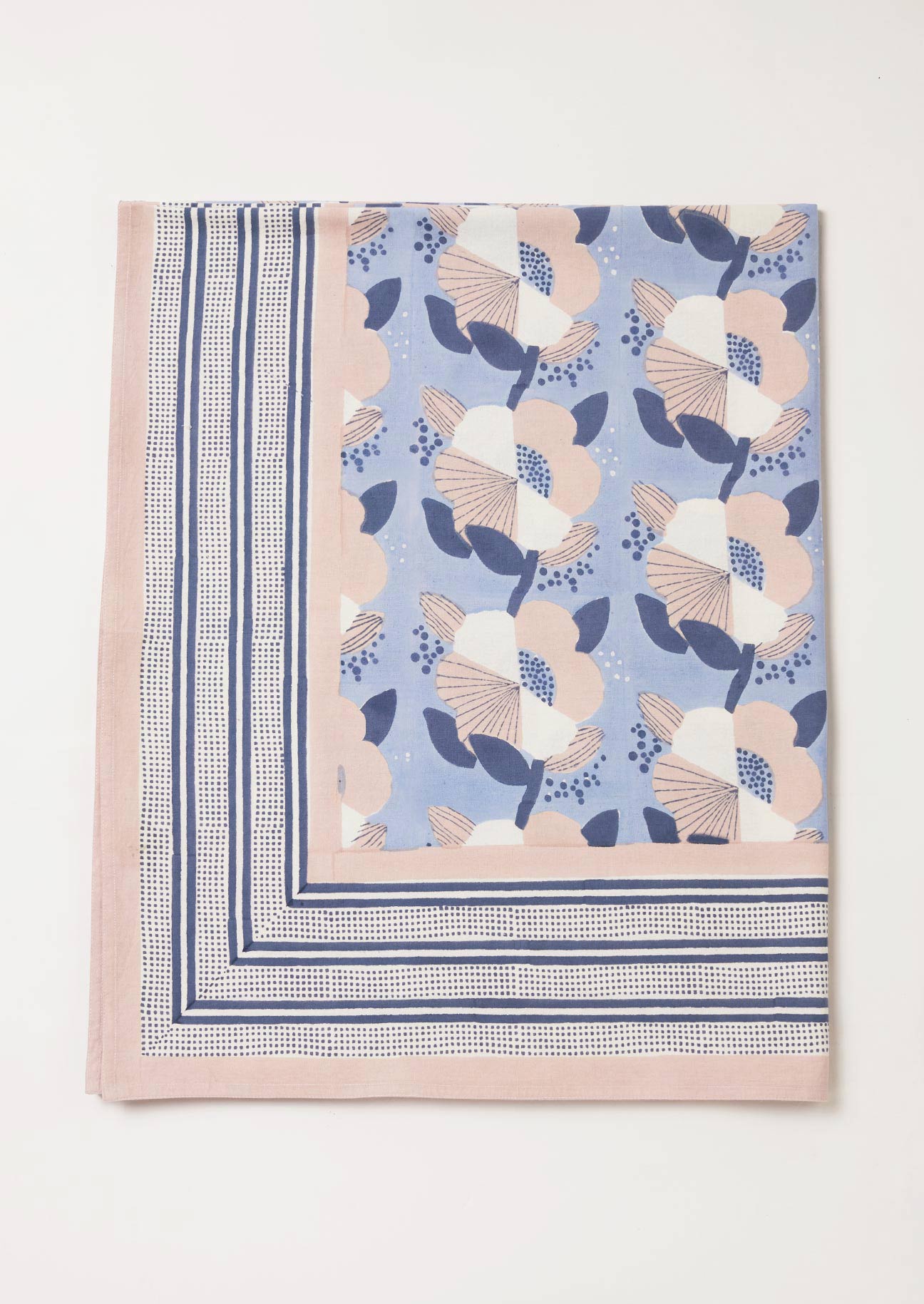 Detail of blue, navy and pink handmade floral tablecloth with stripe border design.