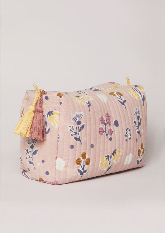 Side detail of yellow and dusky pink tassels on block-printed toiletry bag.